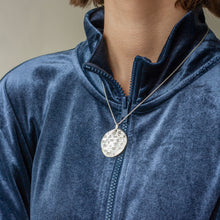 Load image into Gallery viewer, PARAGON II ROUND SILVER PENDANT WITH SQUARE PATTERN ON CHAIN BY MARGO ORLOVIK ON MODEL