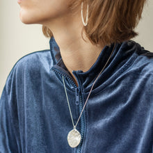 Load image into Gallery viewer, PARAGON II ROUND SILVER PENDANT WITH SQUARE PATTERN ON CHAIN BY MARGO ORLOVIK ON MODEL