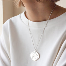 Load image into Gallery viewer, PARAGON I OVAL ORGANIC SHAPED SILVER PENDANT WITH SQUARE TEXTURE ON CHAIN BY MARGO ORLOVIK ON MODEL