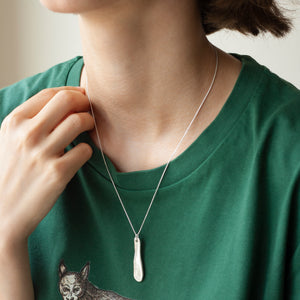 PARAGON VII ORGANIC OBLONG SILVER PENDANT WITH SQUARE PATTERN ON A CHAIN BY MARGO ORLOVIK ON A MODEL