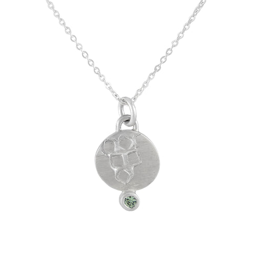 Delicate round, textured silver pendant with 2mm green sapphire | Imprint Collection | Margo Orlovik