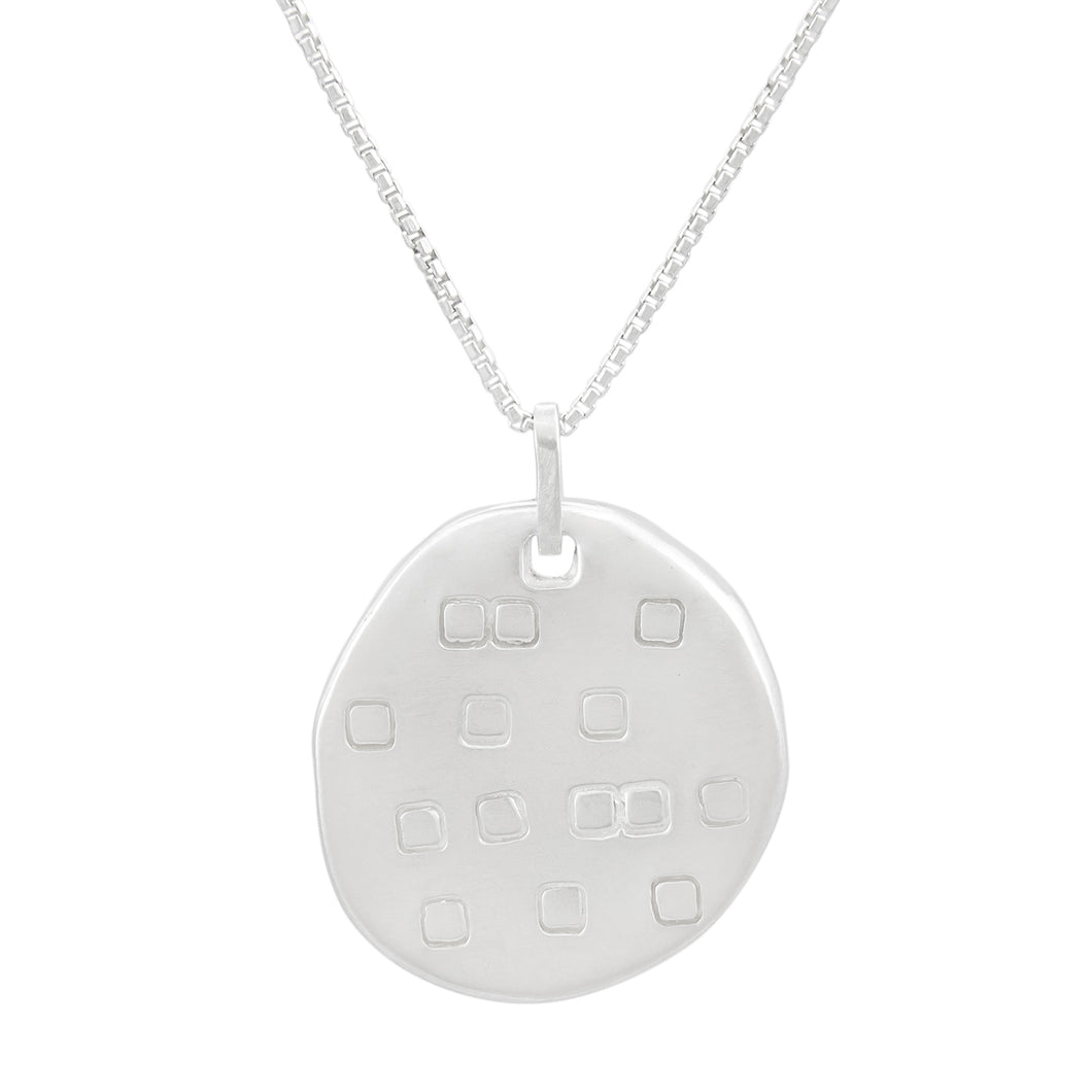 Organic shaped silver pendant with square pattern, on a chain.